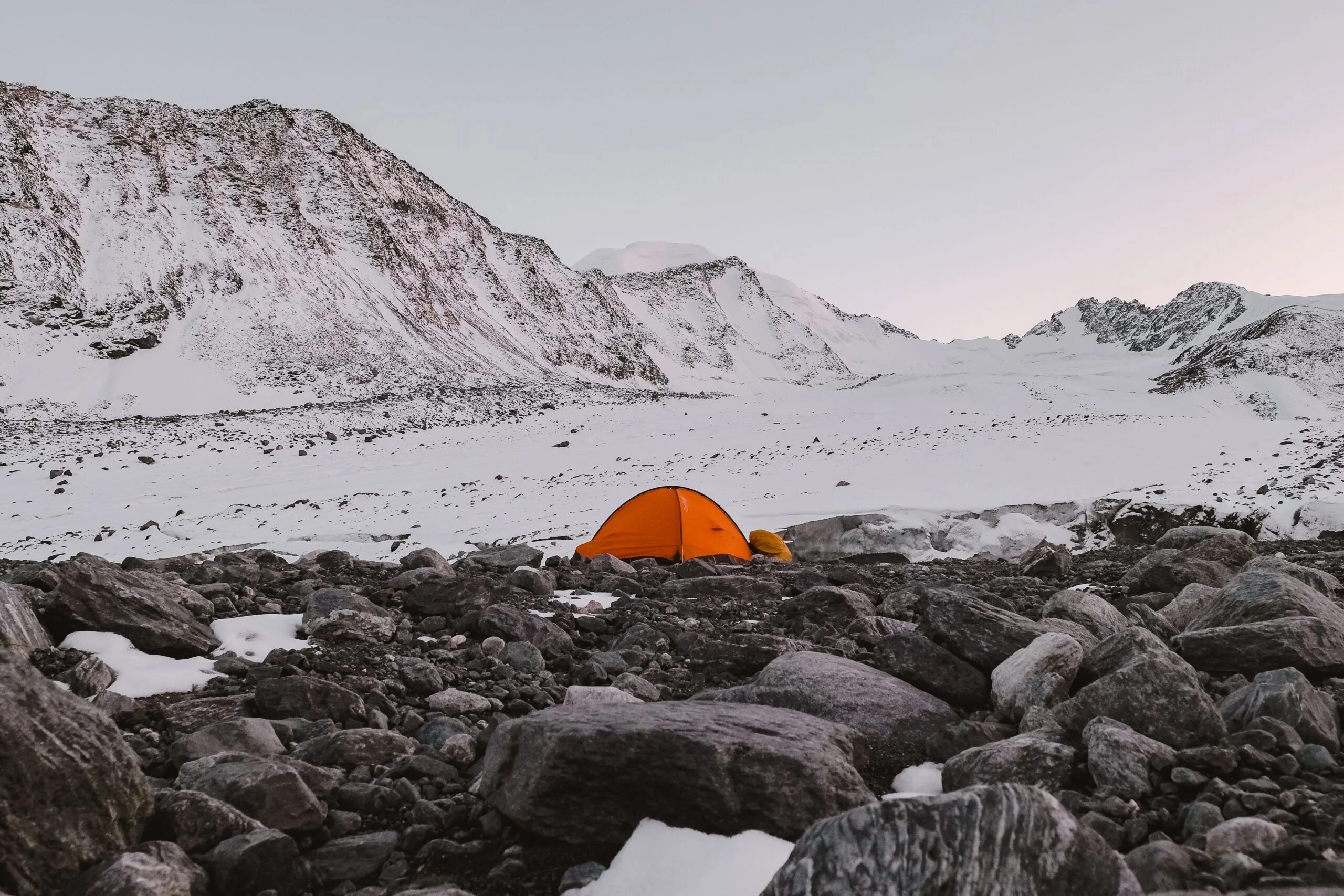 Orange tent in snowy mountain area